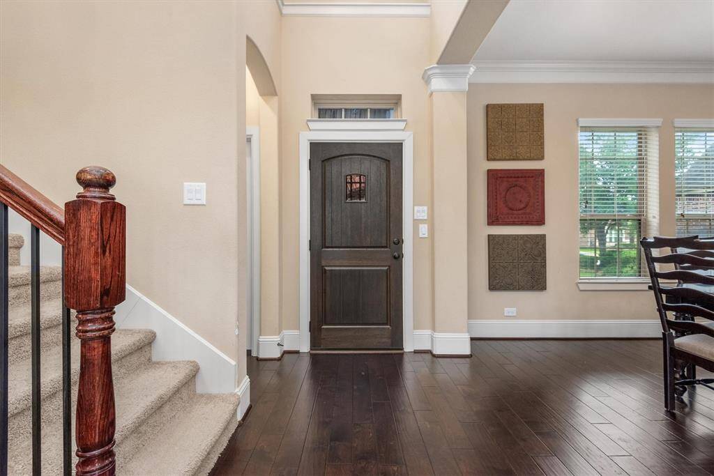 This beautiful entry way has a dark rich mahogany door with natural light from above.