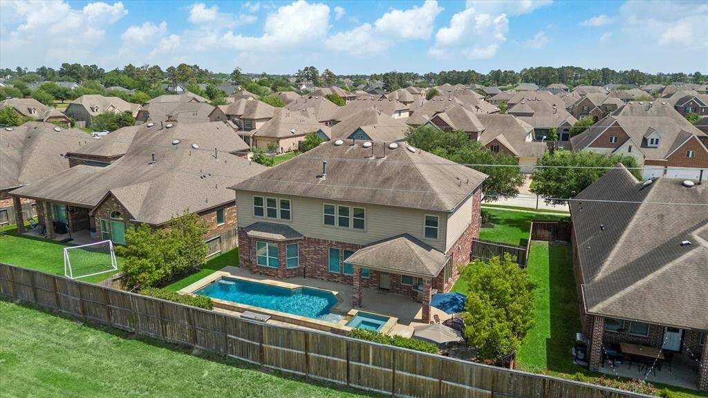 This aerial view captures the sparkling blue pool and greenspace behind the home.  This is tranquil outdoor living.