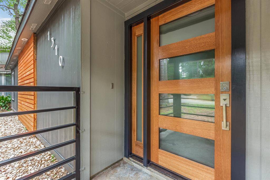 The front of the home is accented by a modern design custom door.