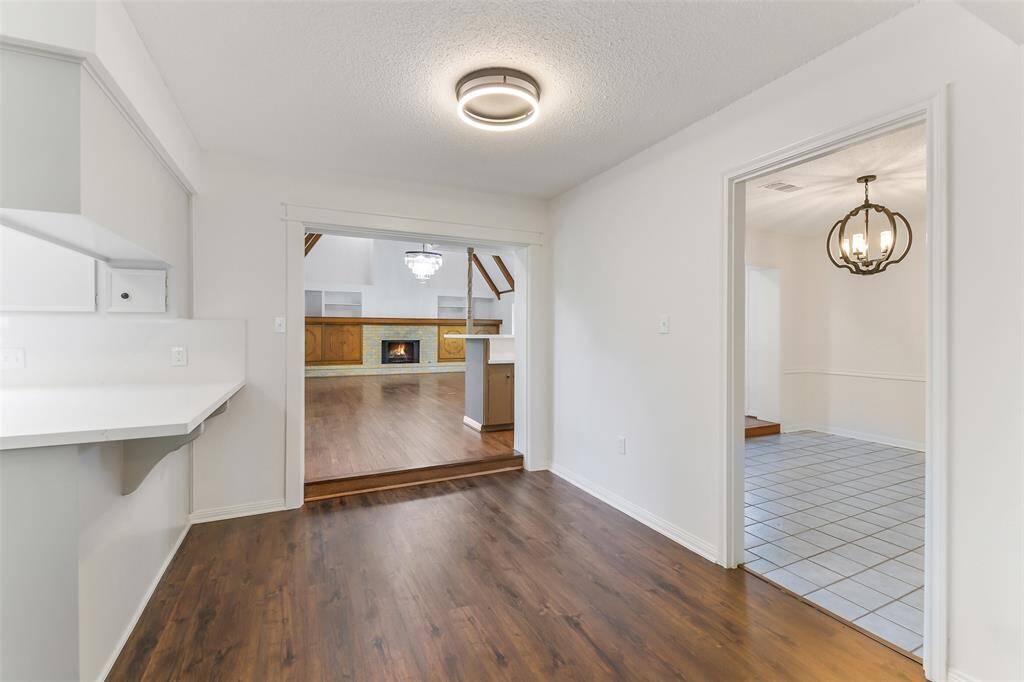 “Spacious main living area featuring warm wood floors, a cozy fireplace, custom built-ins, and open flow into the breakfast nook and formal dining room.”