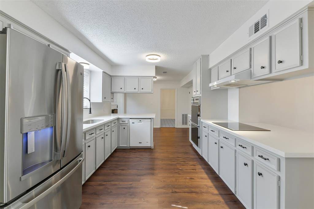 “Updated kitchen with quartz countertops, painted cabinets, and a vintage oven—refrigerator included!”