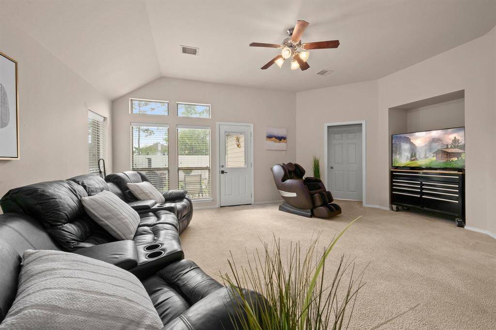 Spacious, carpeted living room with natural light.