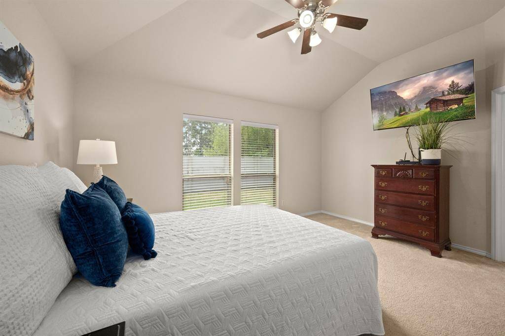 Peaceful primary bedroom retreat with cozy carpeting and ceiling fan.
