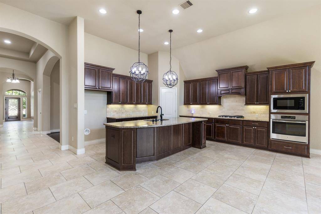The kitchen welcomes you with sleek stainless steel appliances to include a (2023) GE profile 2.2 cubic inch microwave and KitchenAid 30" gas cooktop with griddle.