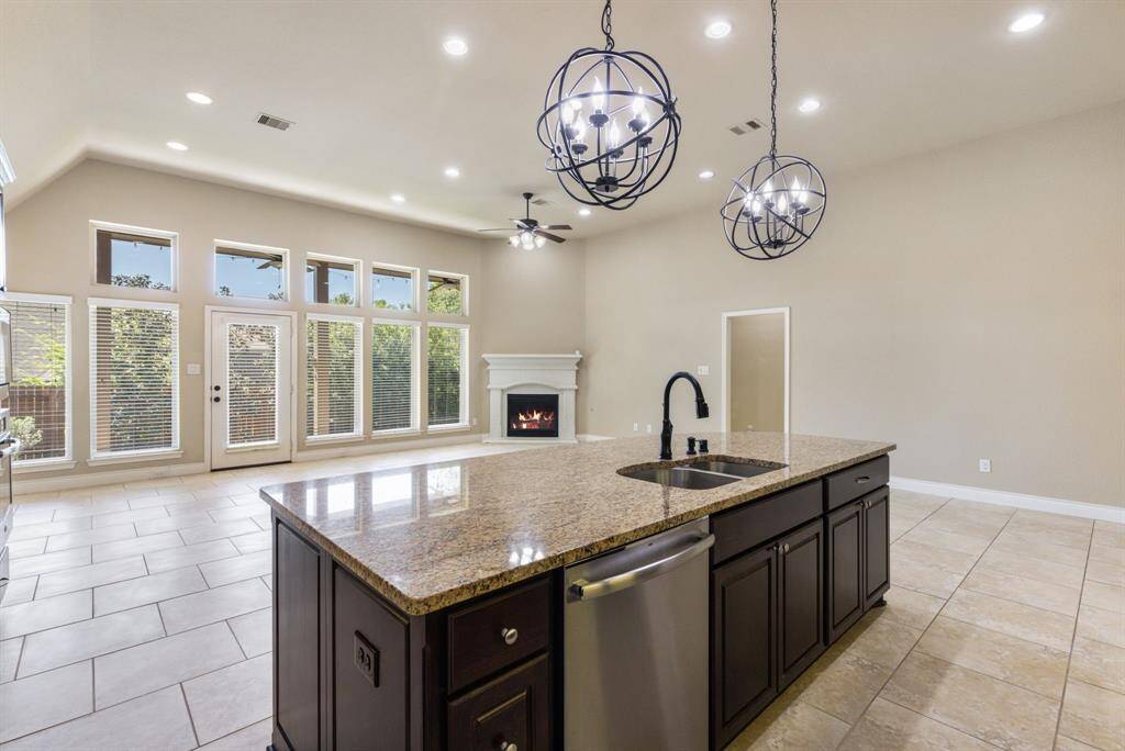 Kitchen Island features electrical outlets, double stainless steel sink, generous seating and storage.