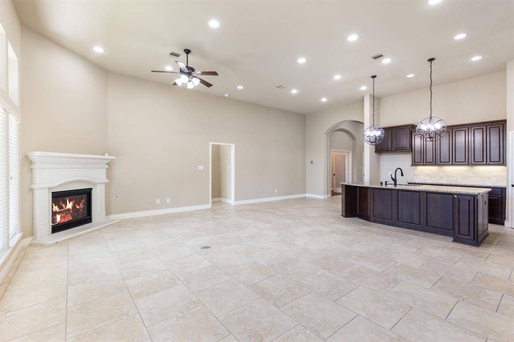 The family room highlights a gas fireplace and a wall of windows that flood the space with natural light.
