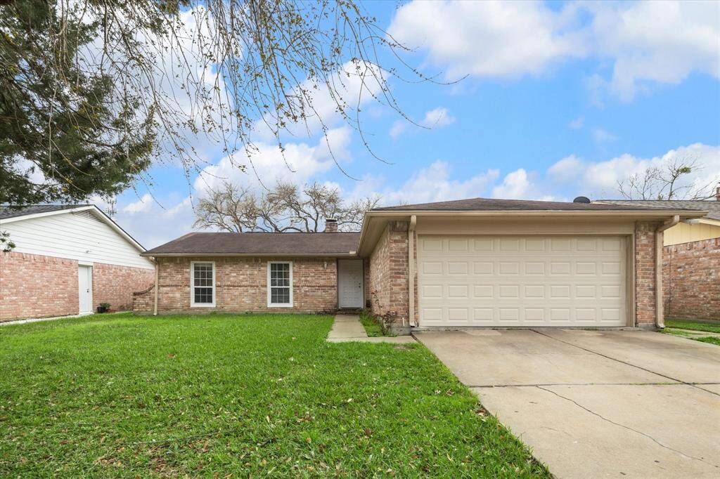 This cozy single-story brick home features a two-car garage, a spacious front lawn, and a simple, welcoming facade. Ideal for family living.