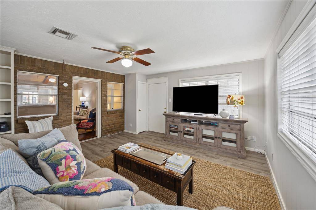Expansive den filled with natural light from three walls of windows—an ideal space for both entertaining and relaxation.