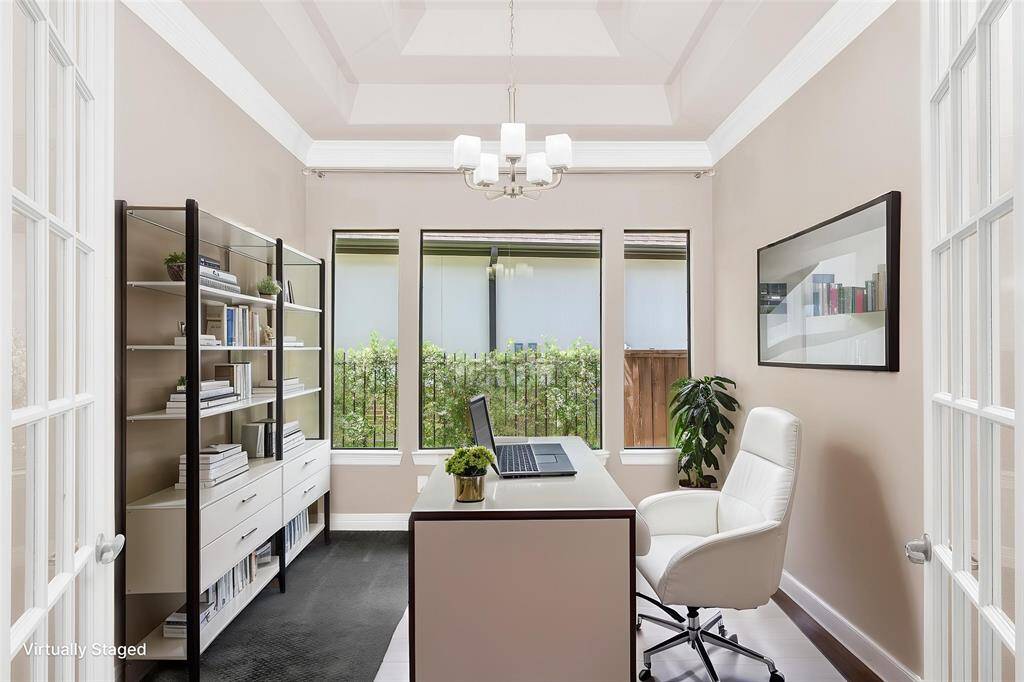 Home office or study featuring an elegant tray ceiling and classic French doors.