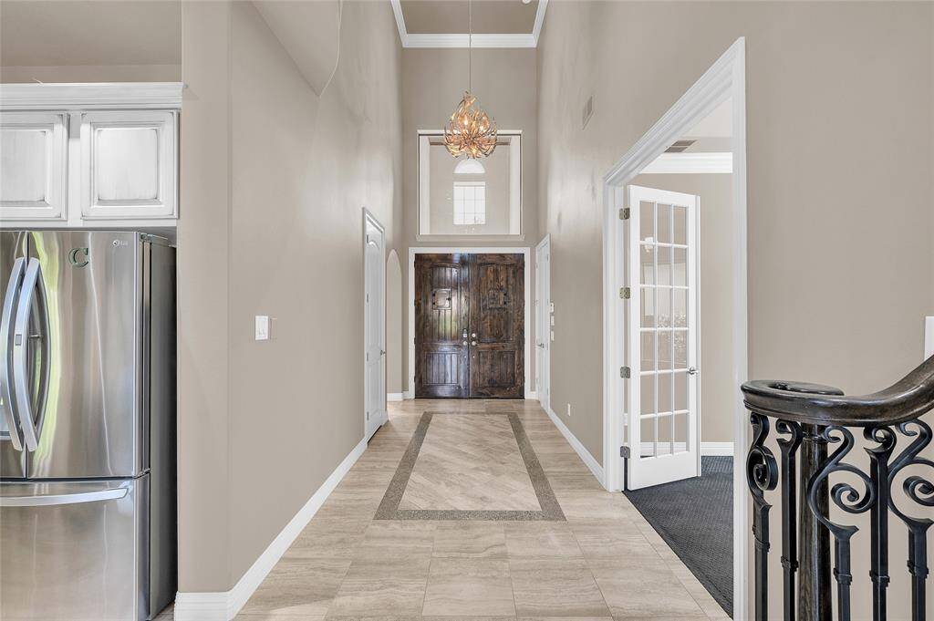 Soaring ceilings highlighted by a custom chandelier, complemented by intricate tile flooring details.