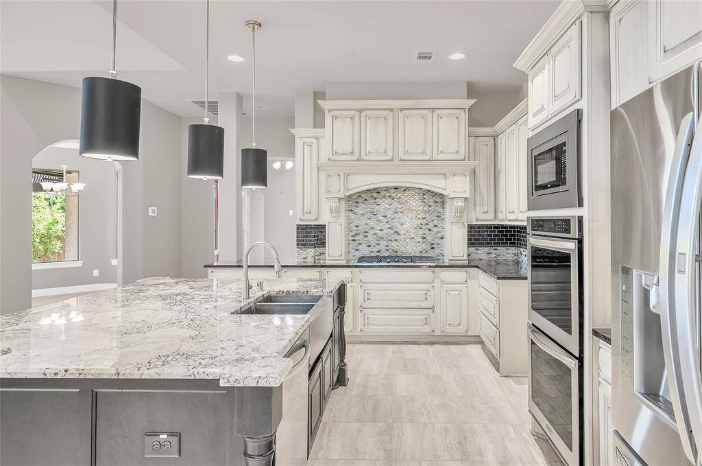 Exquisite custom cabinetry paired with a beautifully upgraded tile backsplash.