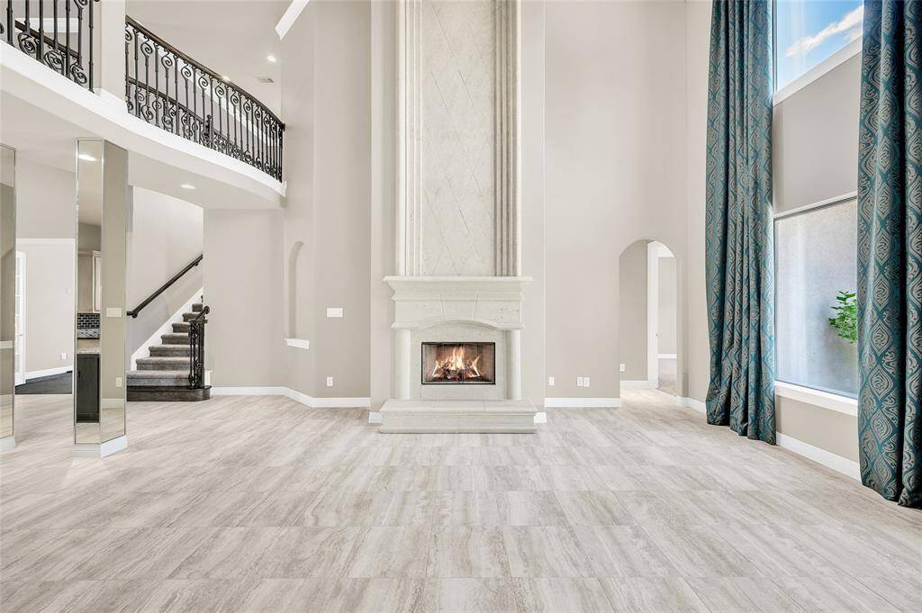 Striking floor-to-ceiling stone gas fireplace, serving as a dramatic focal point in the room.