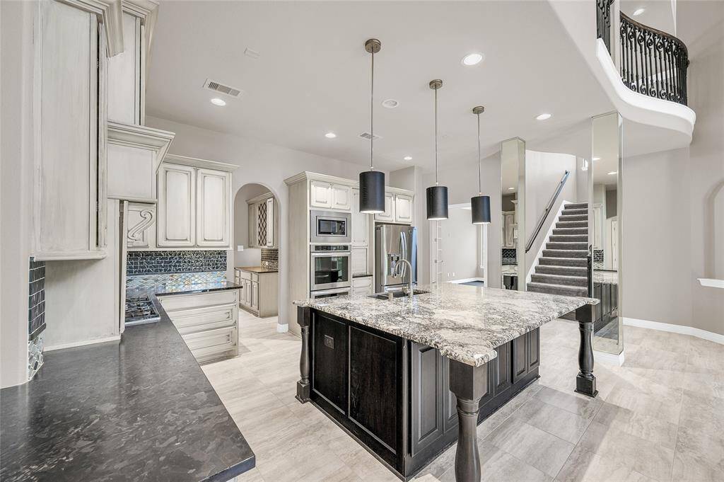Upgraded granite countertops, a stylish tile backsplash, and elegant pendant lighting.