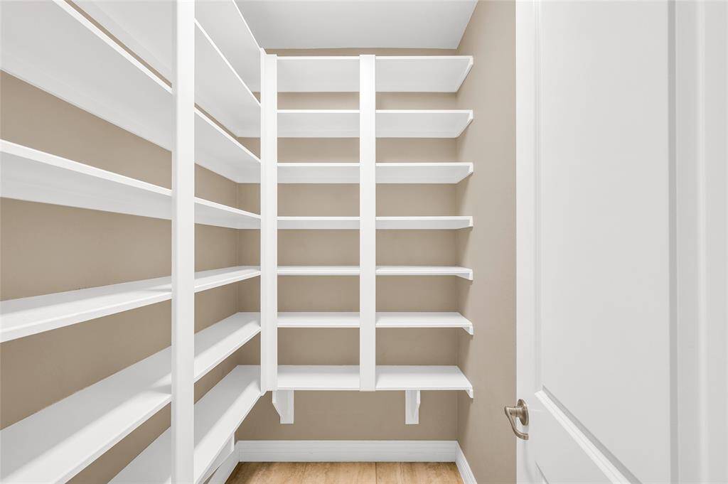 Spacious walk-in pantry with floor-to-ceiling shelving.