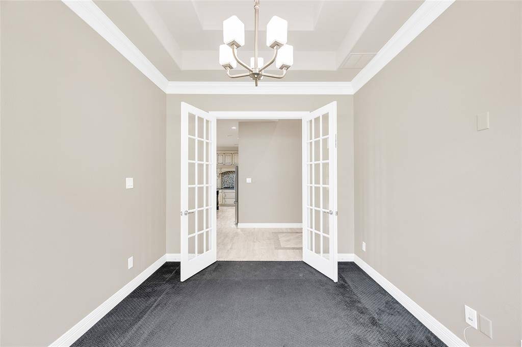 Home office/study with elegant French doors and a tray ceiling.