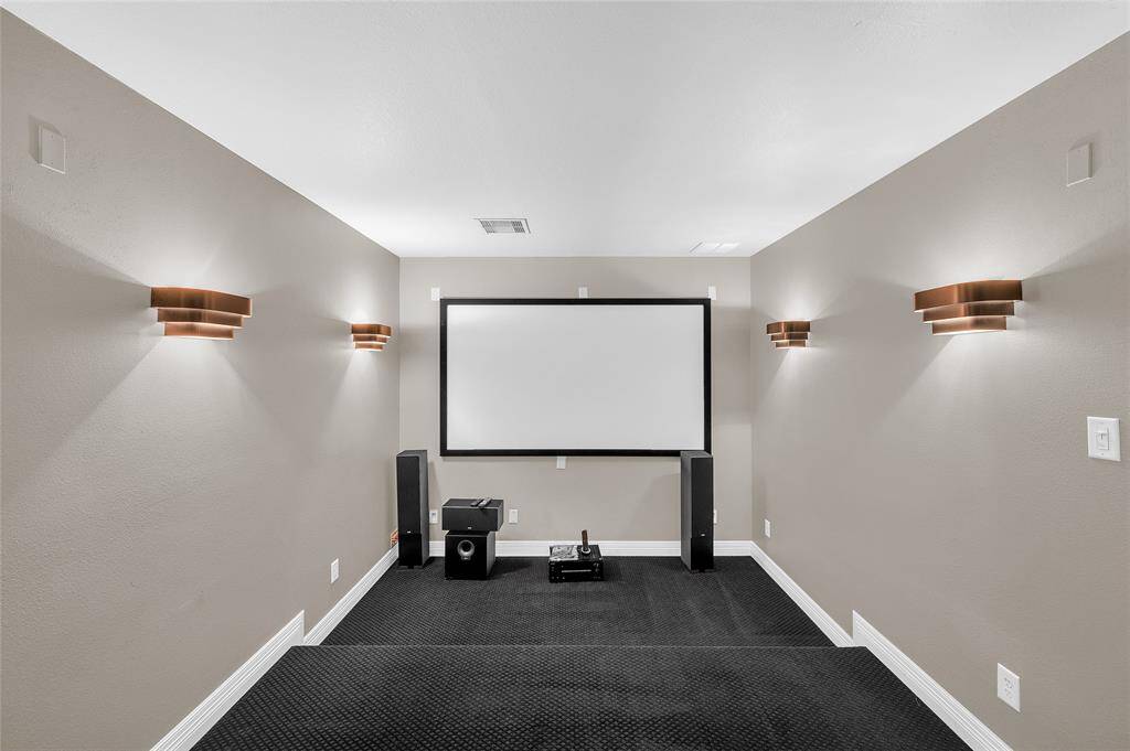 Fully equipped media room with multi-level flooring to enhance seating.