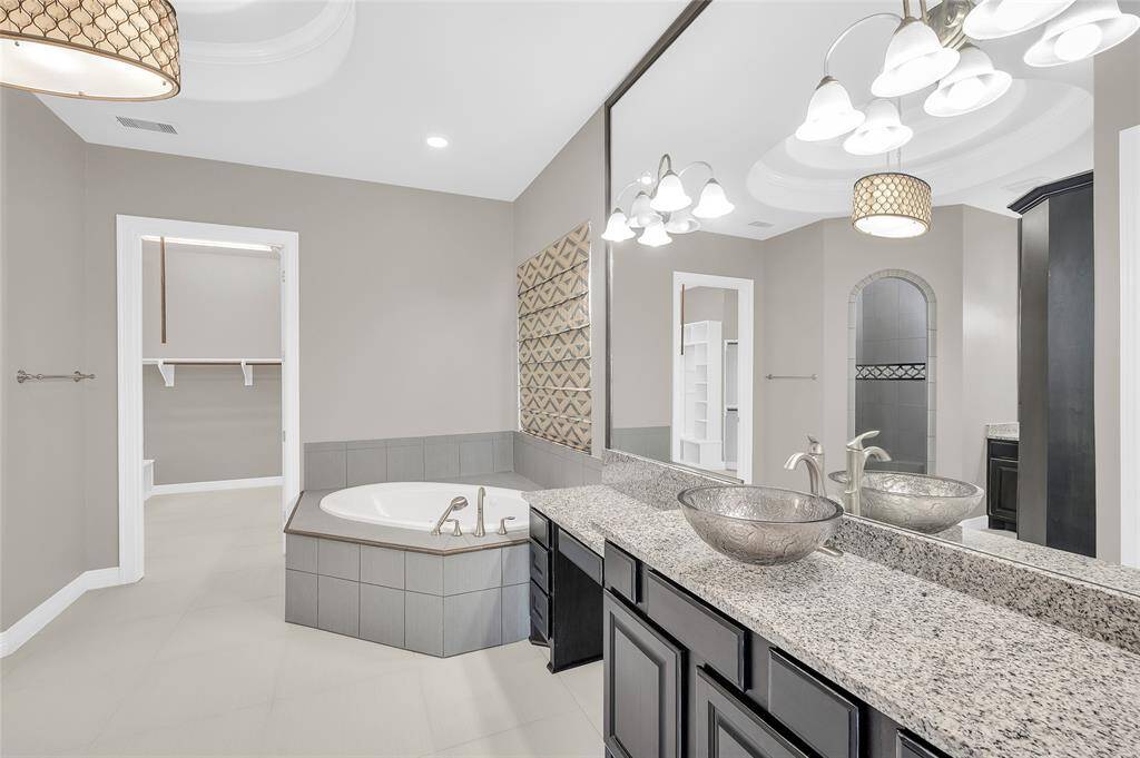 Ensuite bathroom featuring a large soaker tub and his-and-her sinks.