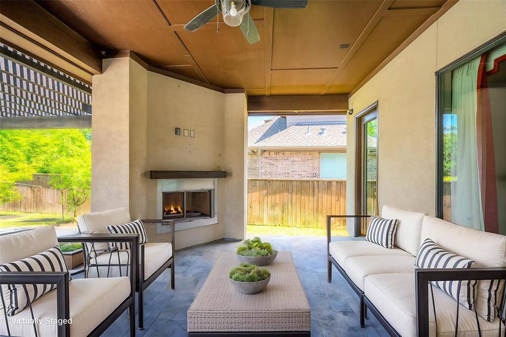 Elegant corner outdoor fireplace beneath the covered patio, perfect for year-round use.