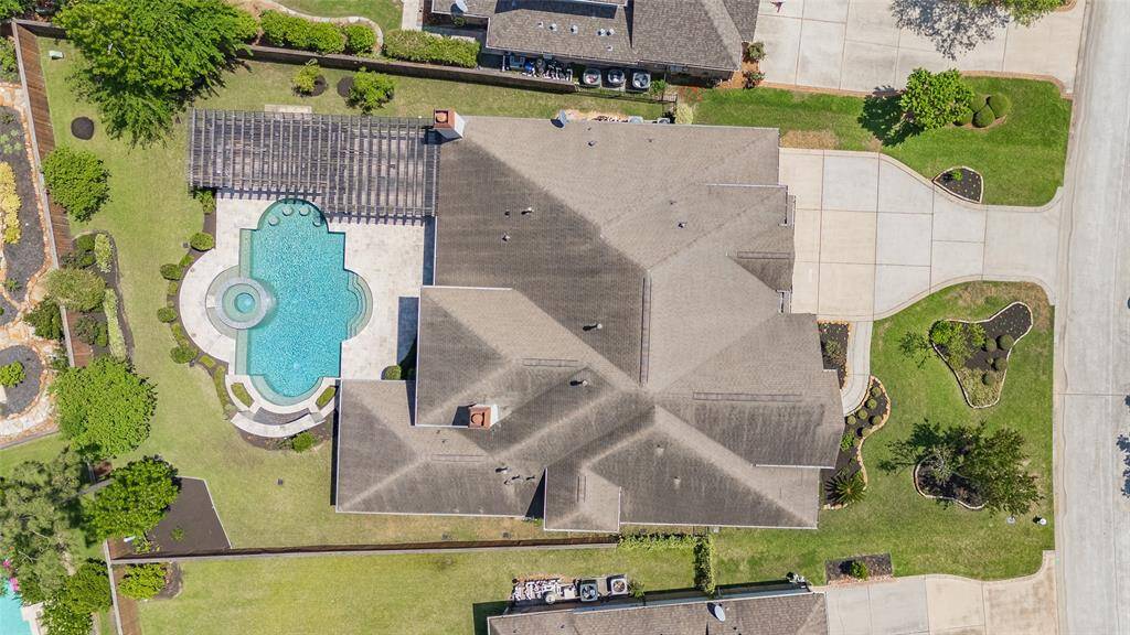 Aerial view of the property, showcasing the custom pool and trellis over the outdoor kitchen.