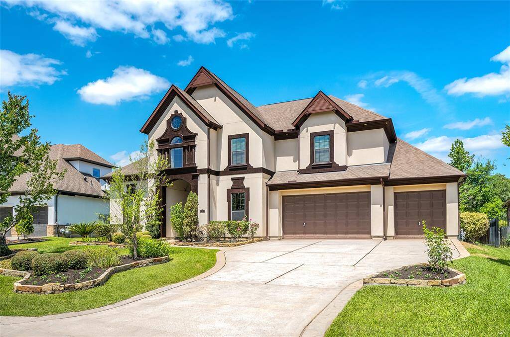 Oversized 3-car garage with an extra-wide driveway, complemented by lush landscaping.