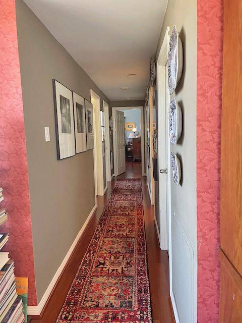 Hallway with bedrooms on left; primary at the end of the hall with north and west views
