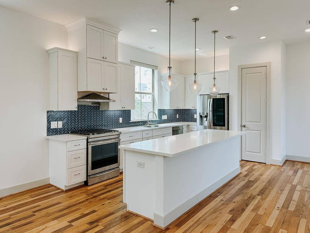 Bright and contemporary kitchen, boasting quartz countertops and a large breakfast island. A perfect place to gather around with friends and family.