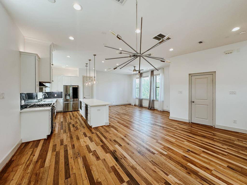 Stunning open-plan living/dining/kitchen area. You will love entertaining in this sunlit room. A half bath is located behind the door on right in this picture.