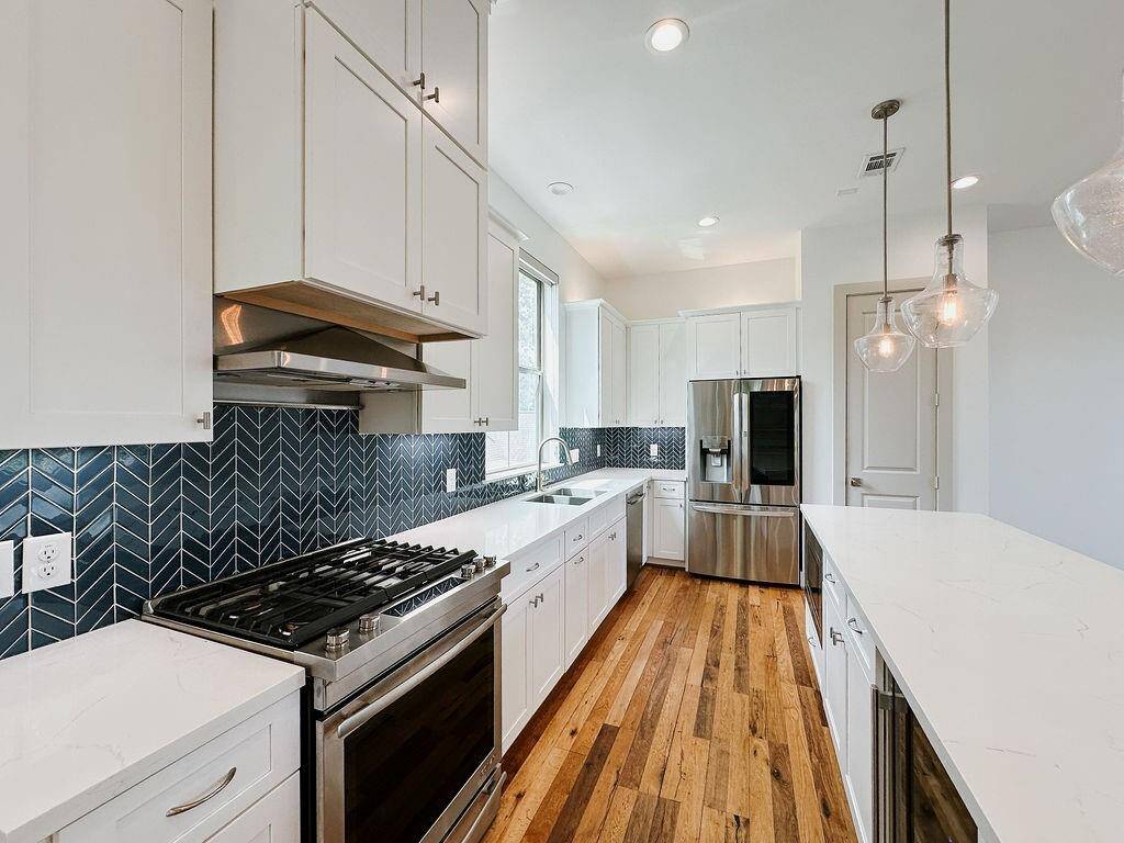 This home is finished with high-end appliances and finishes, including a gas stove oven, wine-fridge, and smart fridge.