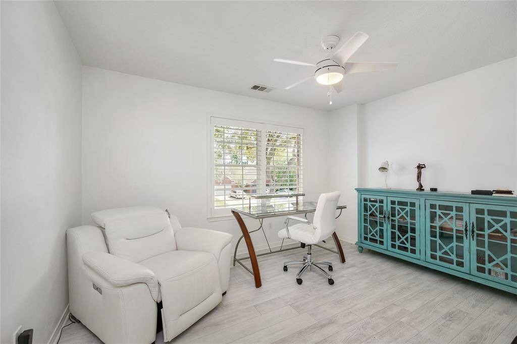 This bright and inviting secondary bedroom, currently being utilized as a office space is filled with natural light from a large window, offering a peaceful environment for productivity. Clean lines, neutral tones, and timeless design elements make it a versatile room—perfect for a home office, study, or creative retreat.