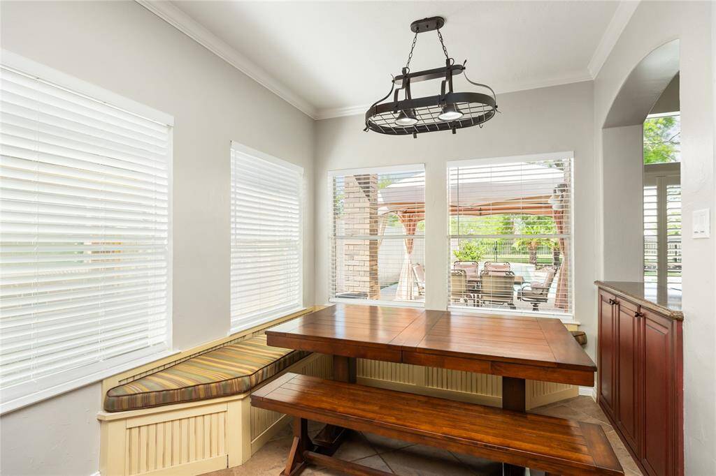 This charming breakfast nook offers a serene spot for morning meals, featuring large windows that bathe the space in natural light. Overlooking the patio, this inviting nook creates a peaceful, cozy atmosphere perfect for enjoying both quiet moments and family gatherings.