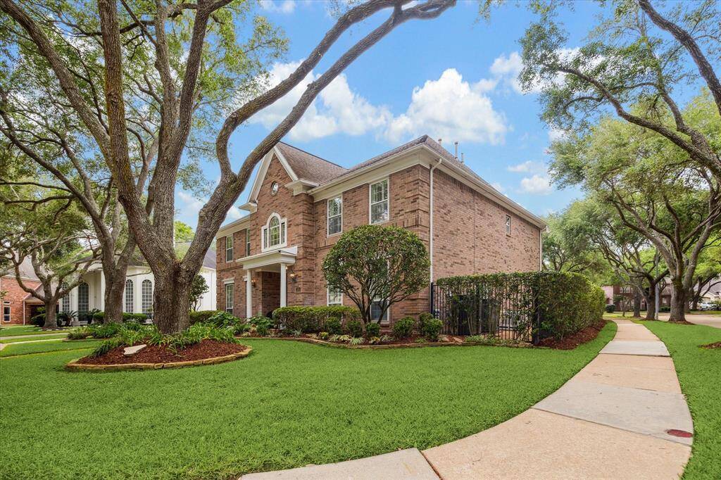 Situated on a corner lot, the home is shaded by beautifully pruned oak trees.