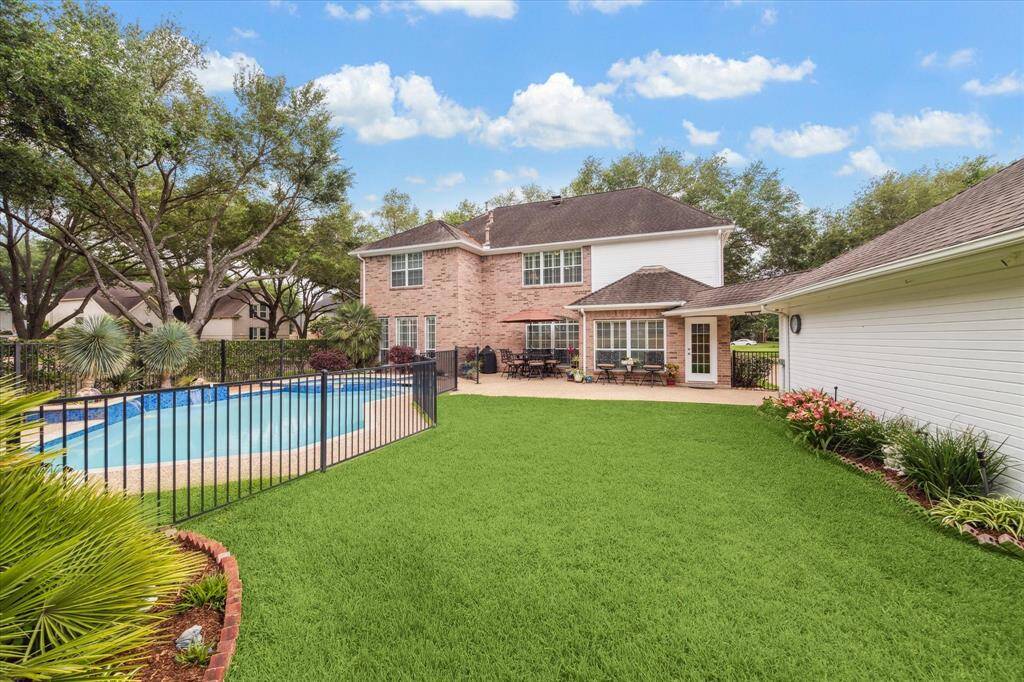 Before we venture inside, lets take a look out back! The pool and spa are heated and is surrounded by a child protection fence.