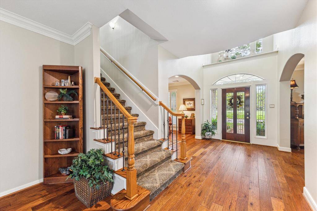 Beautiful hand scraped wood floors cover the entry, study, dining and family room. Two staircases lead you upstairs to the game room and secondary bedrooms. The iron balusters and upgraded carpet on this stairwell match the rich design of this vignette.