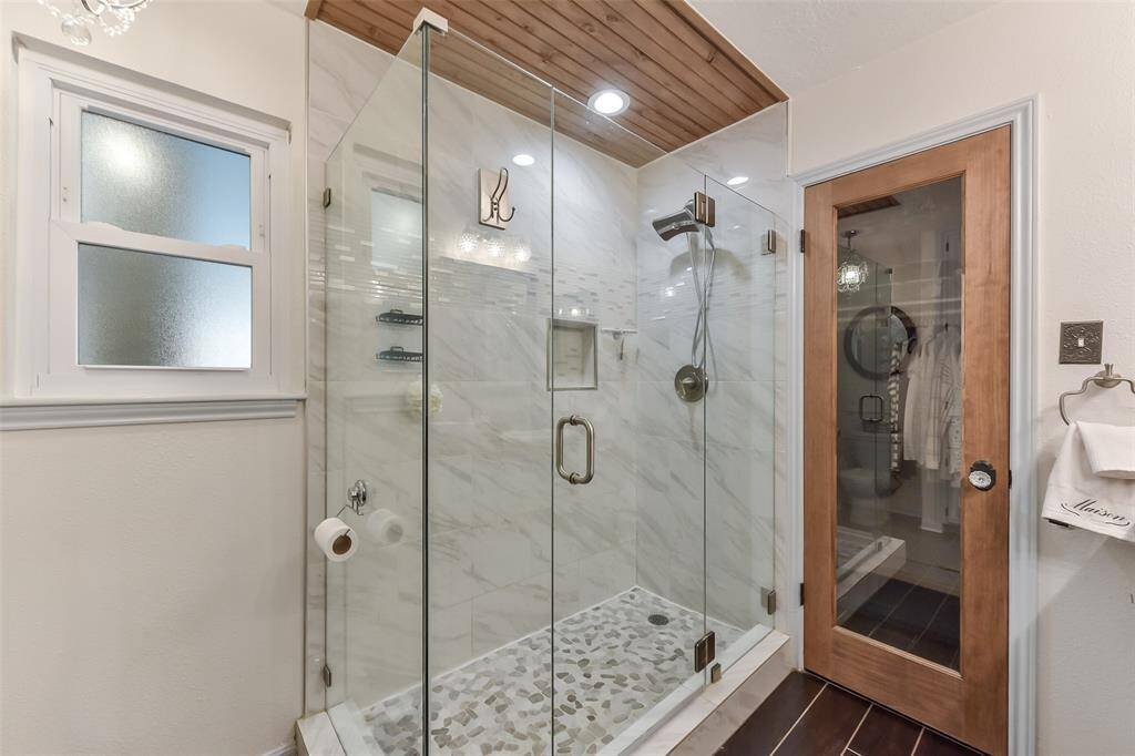 The shower in the primary bath has been expanded and enclosed with glass.