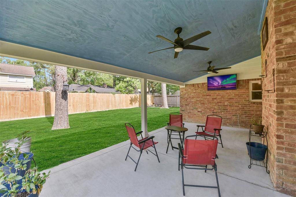 The covered back patio with ceiling fan is a great place to relax.