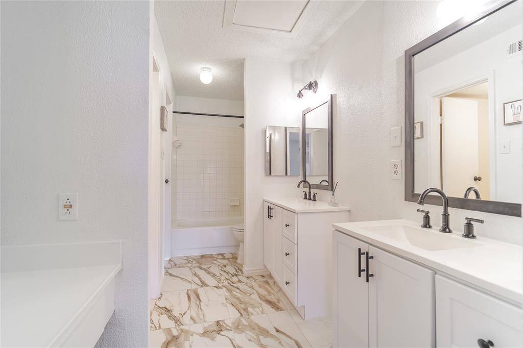 A primary bathroom with a double sink Vanity,marble counter top.