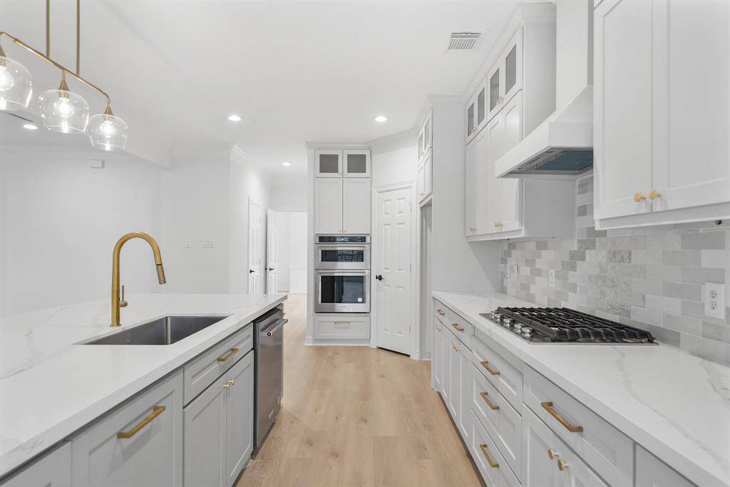 Sleek and modern white cabinetry offers ample storage while enhancing the kitchen’s bright and airy feel.