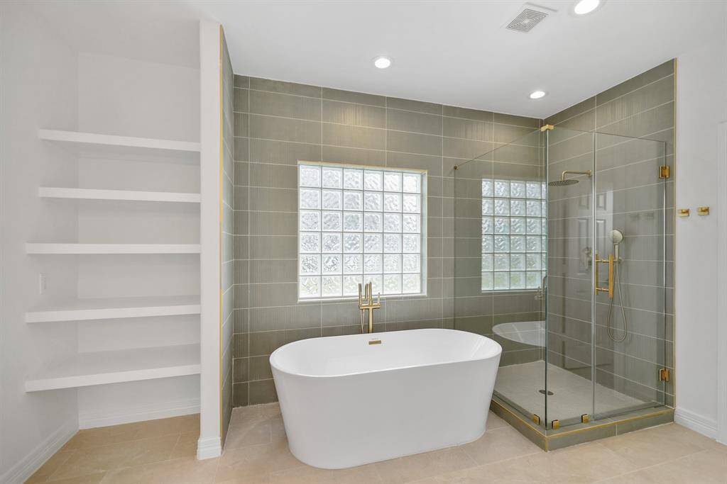 Primary Bathroom also offers a built-in shelving unit with multiple white open shelves, providing storage space for bathroom essentials.