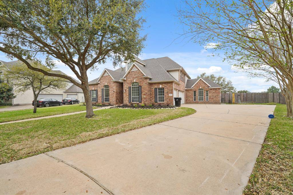 A generously sized driveway provides ample space for multiple vehicles and easy maneuvering.