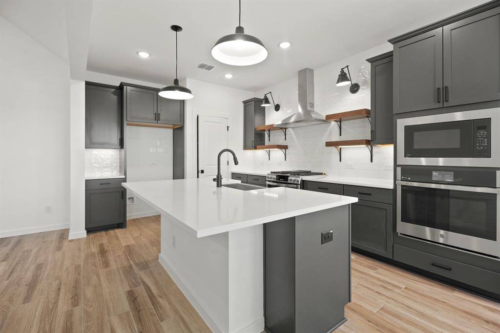 Lovely kitchen with grey cabinets and quartz countertops (*Photo not of actual home and used for illustration purposes only.)