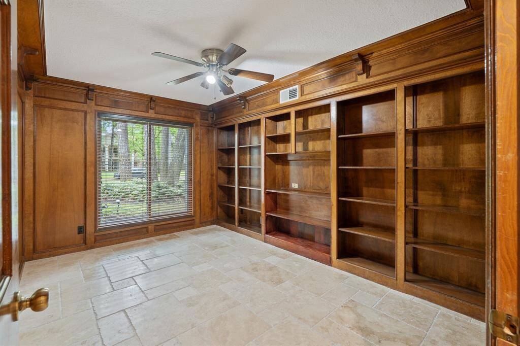 Downstairs office with tons of bookshelves and wood paneling for that custom office feel.