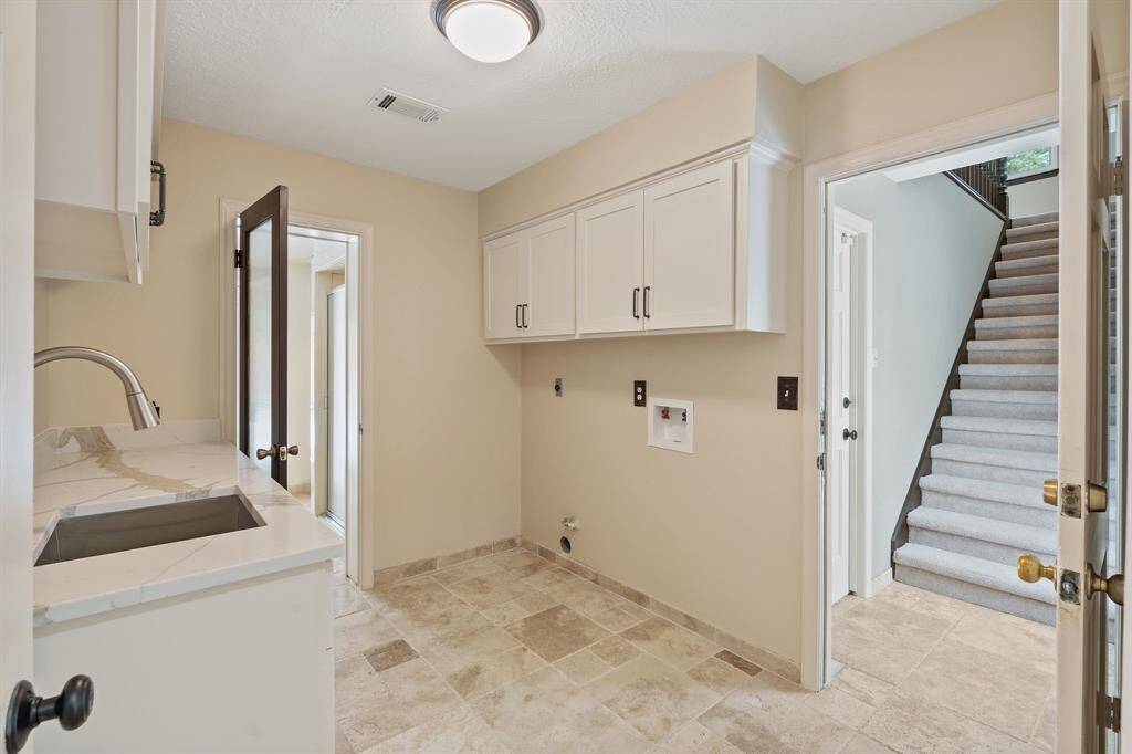 Laundry room with access to second set of staircases leading to gameroom.