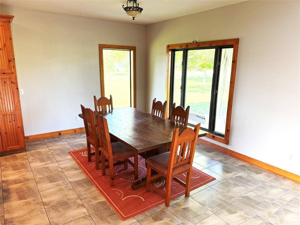 The spacious dining room allows for tables and furniture of all sizes with views of the 2 acre property.
