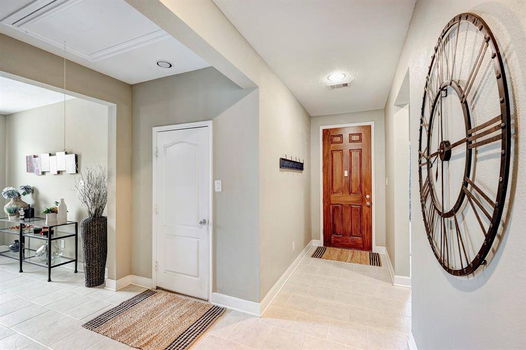 The front entry welcomes you with warm neutral colors and pristine tile flooring. To the left is the entry to...