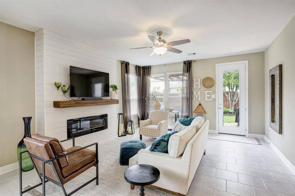 The living room enjoys this shiplap accent and electric fireplace, a cozy addition.