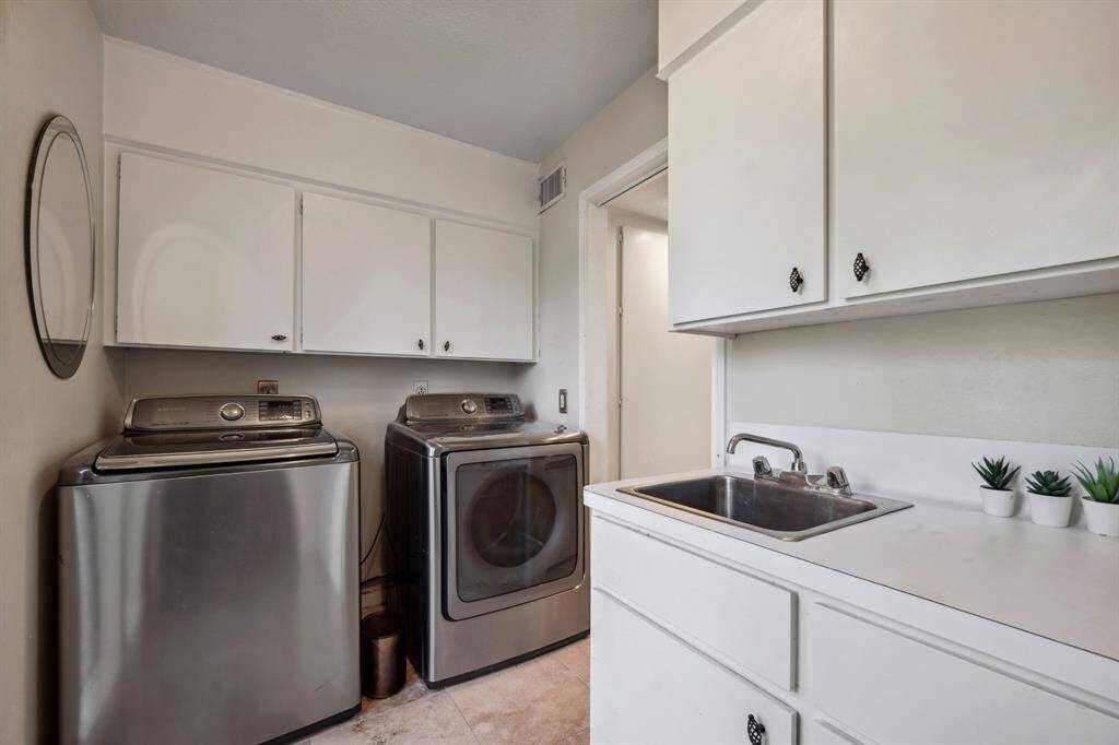 Spacious Laundry Room with Sink and a lot of Cabinets.