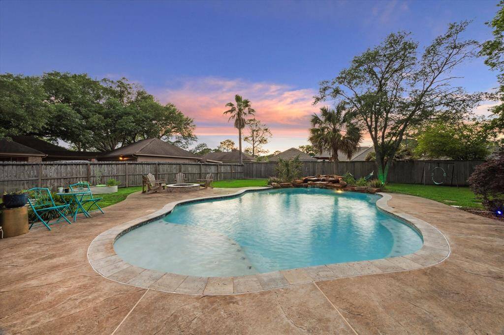 Welcome to outdoor living at it's finest! This back yard will be the setting for so many memory-making moments--swimming, enjoying the fire pit, gardening, swinging, lounging in a hammock or even playing a game of kickball!