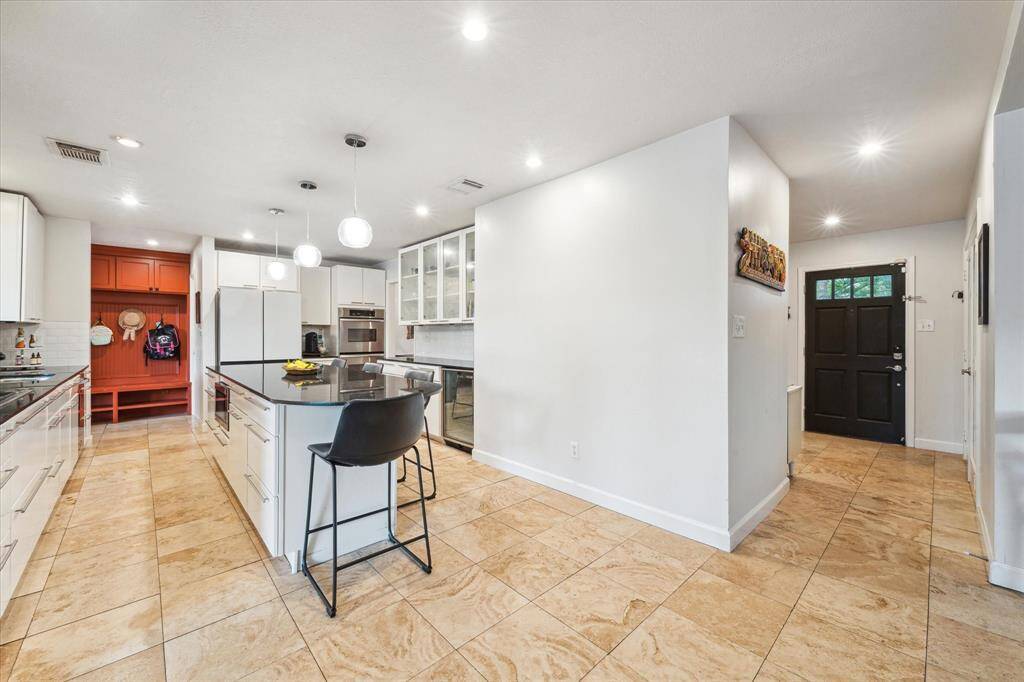 The gorgeous Travertine tile continues from the entry into the spacious kitchen and back entry giving the home great visual appeal!