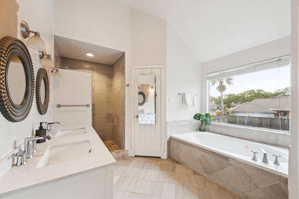 Primary bath has double sinks, jetted garden tub with a view, a bidet in the commode, spacious walk-in closet and a huge spa-like shower.  Mirror wall is being painted.