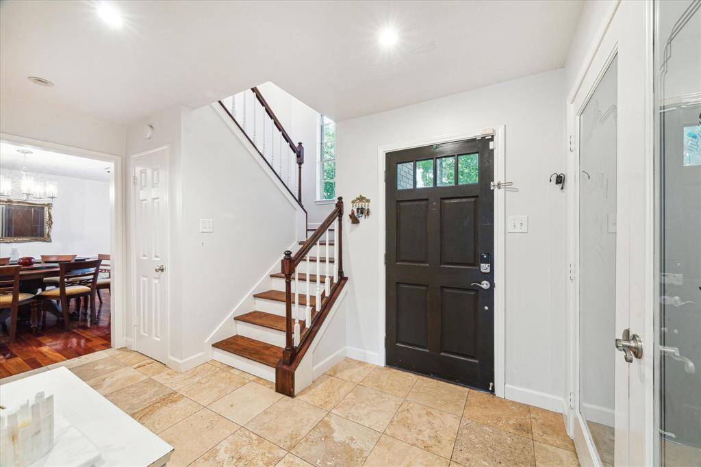 The entry features beautiful Travertine tile floors and space to welcome guests.